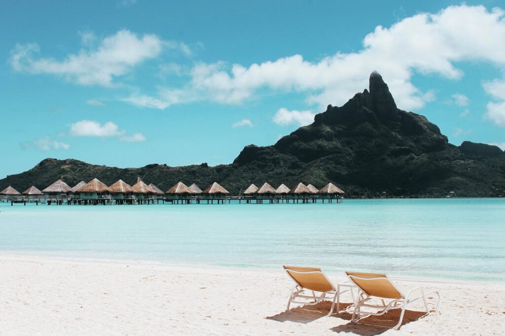 pexels-photo-1174732 Pristine beach with loungers facing turquoise waters and iconic Mount Otemanu in French Polynesia.